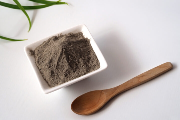 Cosmetic clay in a bowl and a wooden spoon