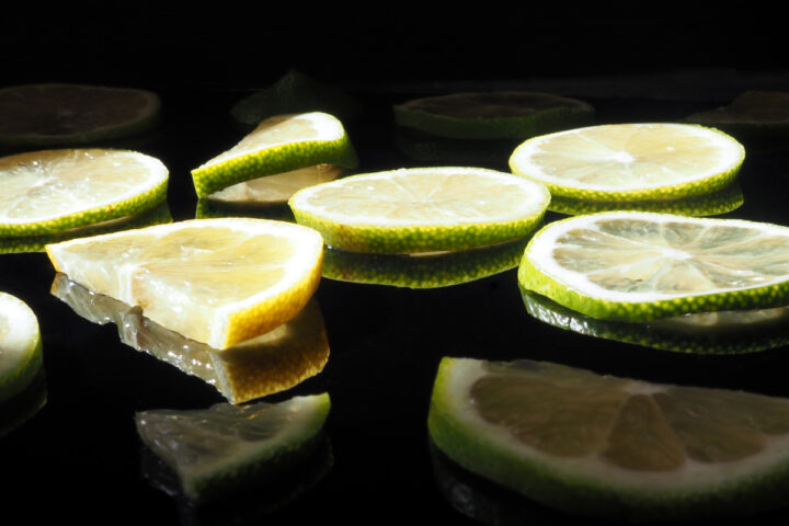As fatias de limão são refletidas em uma superfície preta